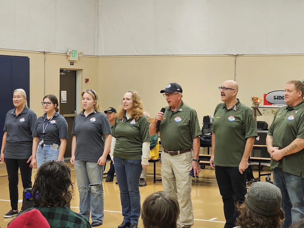 VOC volunteers speaking to students in a school gym